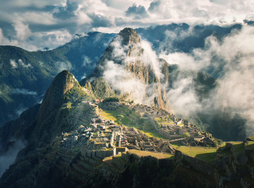 Ancient Inca citadel of world landmark Machu Picchu at sunrise with mist-shrouded Andes mountains