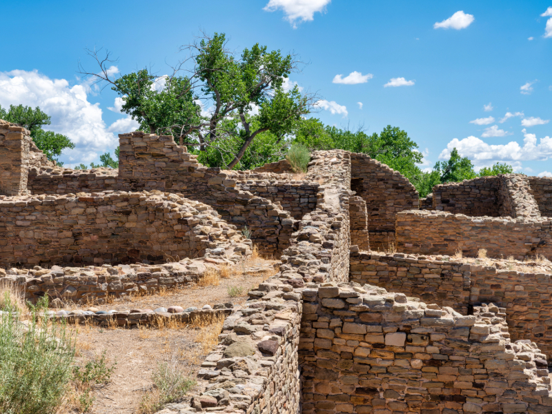 "West Pueblo at Aztec Ruins National Monument in New Mexico, showcasing 12th-century ancestral Puebloan stone structures with intricate masonry and a central pathway."