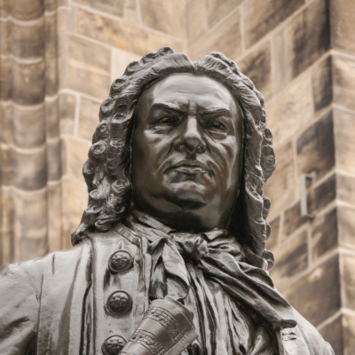 "Bronze statue bust of Johann Sebastian Bach, one of the historical figures who changed the world - Baroque composer with stern expression wearing period wig and formal coat"