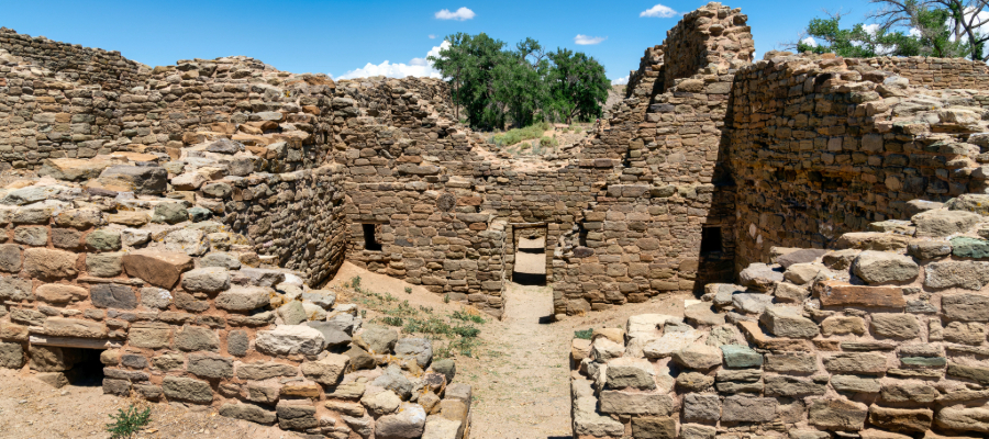 "Aztec Ruins National Monument in New Mexico, showcasing 12th-century ancestral Puebloan stone structures with a central path winding through the ancient buildings."