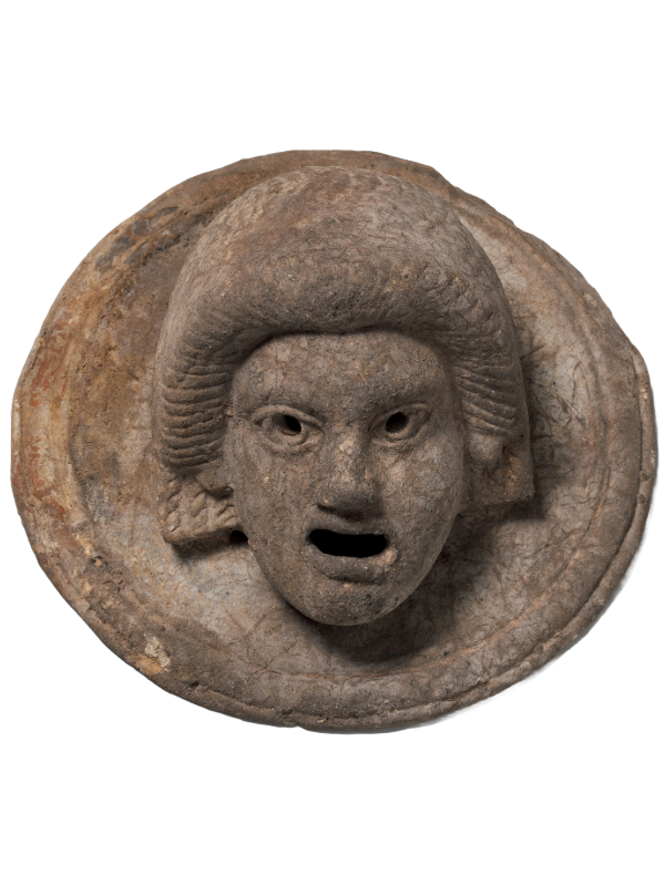 A terracotta figurine of an actor wearing a theatrical mask, representing ancient Greek or Roman theater. The figurine showcases the exaggerated features and expressive details typical of theatrical masks.