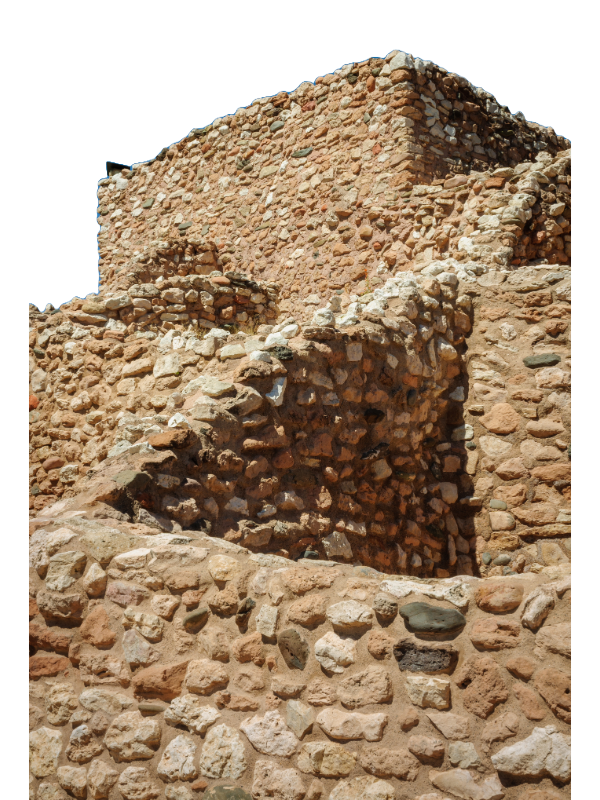 "The image shows a section of Tuzigoot National Monument, featuring the ruins of Tuzigoot Pueblo. The structure is built from reddish-brown stones of varying sizes, stacked to form uneven walls that show signs of age and weathering. The clear blue sky above contrasts with the ancient ruins, which are perched on a ridge overlooking the Verde River valley in Arizona. This pueblo, built by the Sinagua people between 1125 and 1400 AD, once had over 100 rooms and housed around 250 people."