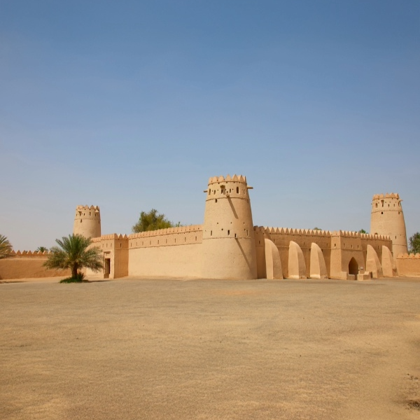 Traditional Omani architecture with forts, dunes, and mountain vistas under a clear sky.