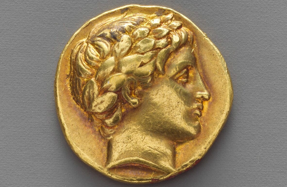 Ancient Greek gold coin (18mm diameter) featuring a laureate bust in high relief, struck during the early Hellenistic period.