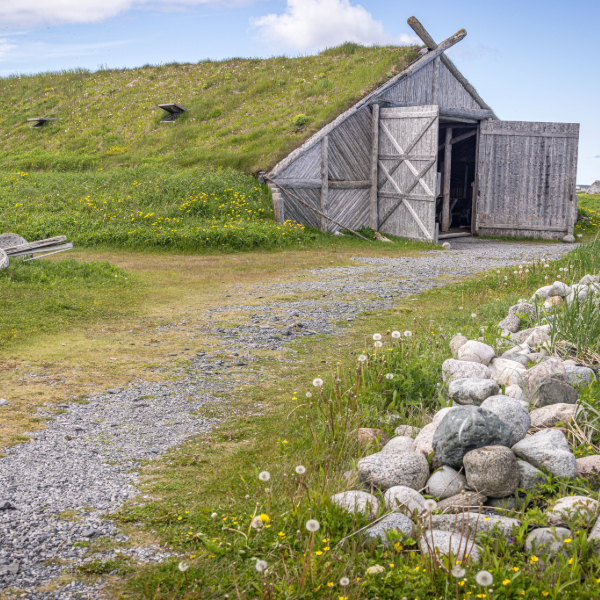 Reconstructed Norse longhouses at L’Anse aux Meadows, Canada, evidence of Viking voyages. Countries that start with C.